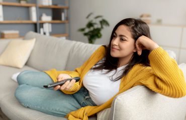 Woman-watching-tv-yellow-sweater