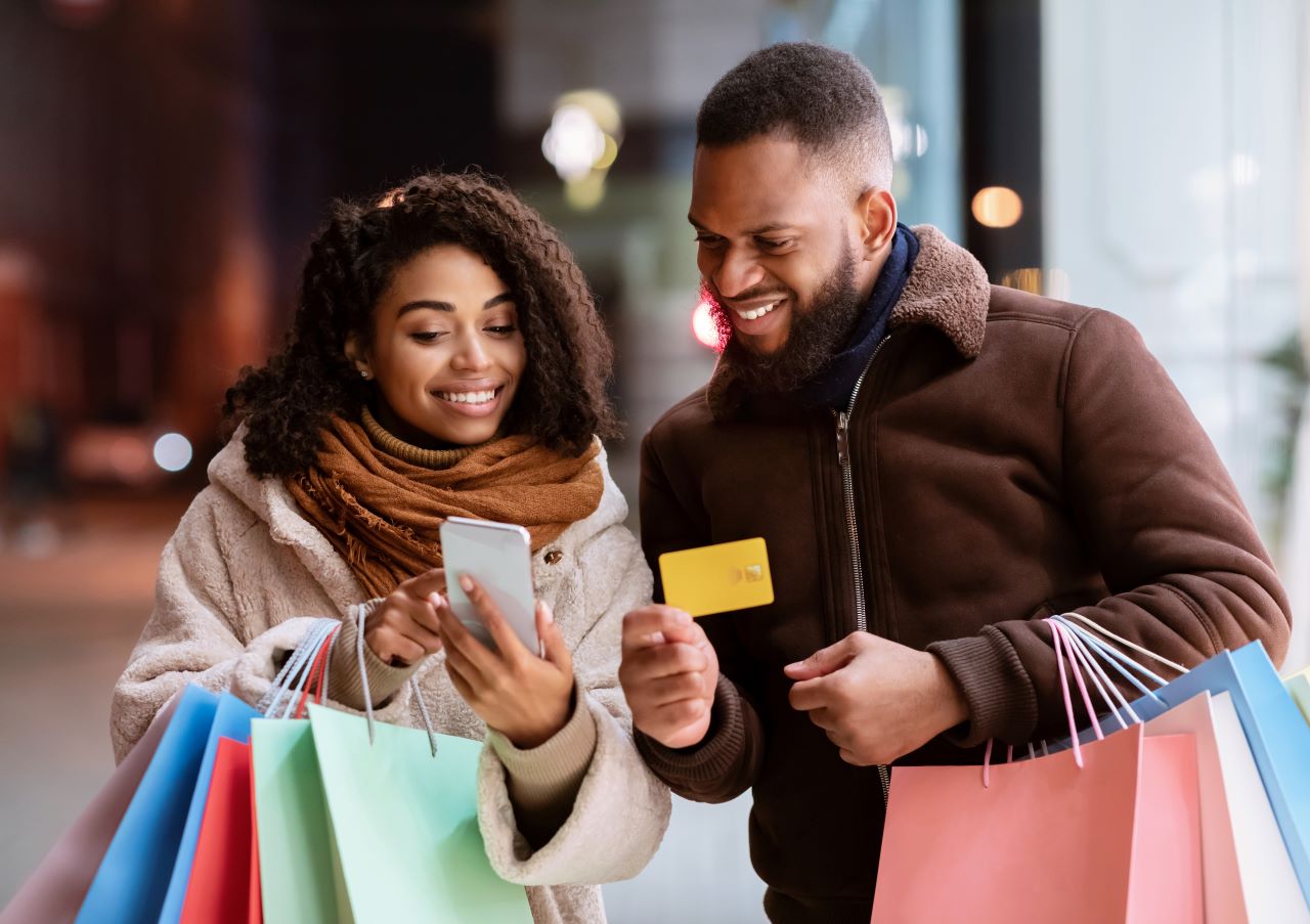 African American man and women shopping and using mobile