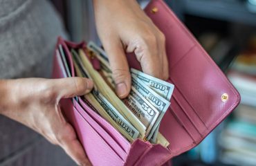 women taking out dollar bills out of wallet