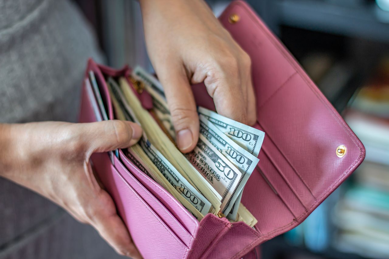 women taking out dollar bills out of wallet