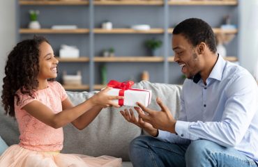 A little girl giving her dad a gift for Father's Day