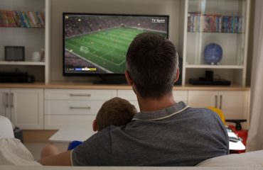 Father and Son at home watching sports on TV