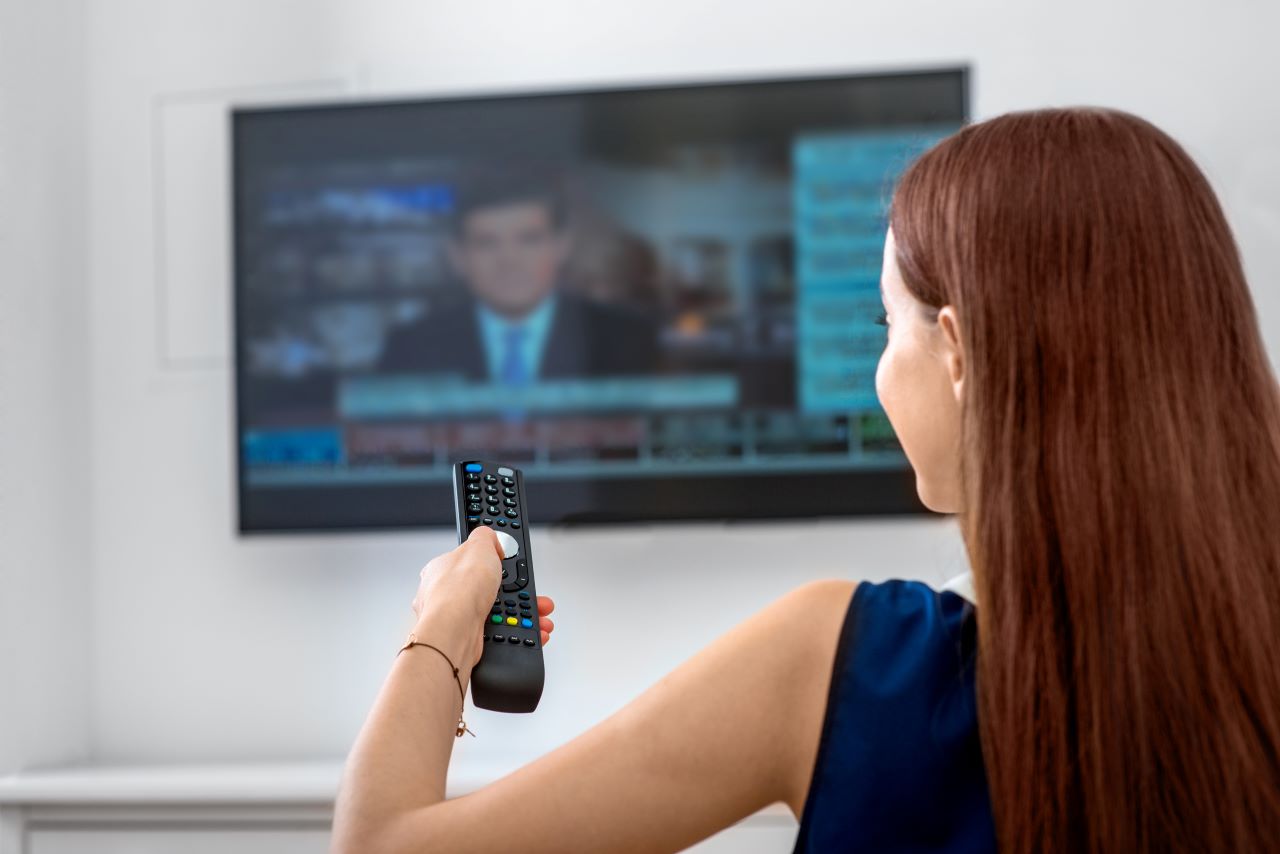 Woman at home watching the news on TV