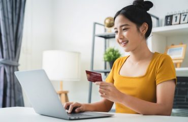 Young female at desk with computer and credit card in hand
