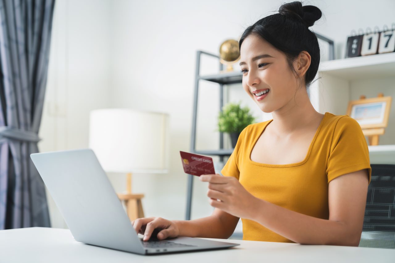 Young female at desk with computer and credit card in hand